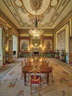 an ornate dining room with chandelier and wooden table in it's center