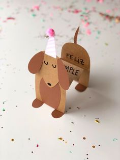 a paper dog with a party hat on it's head