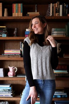 a woman standing in front of a bookshelf