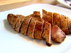 sliced meat sitting on top of a white plate