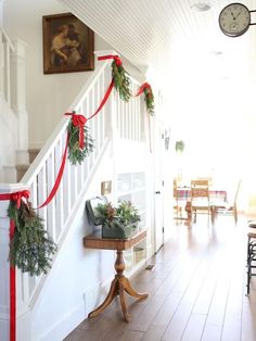 a staircase decorated with christmas garland and greenery