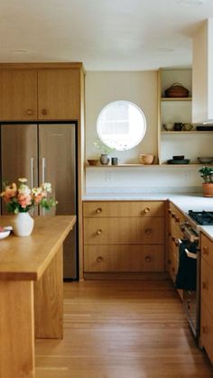 a kitchen with wooden cabinets and an island in front of the stove top is filled with flowers