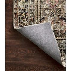 the area rug is laid on top of a wooden floor and has a dark brown background