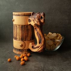 a close up of a wooden object near a bowl of nuts