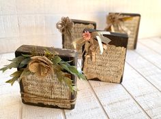 three small wooden boxes decorated with ribbons and twine tied to them, sitting on a table