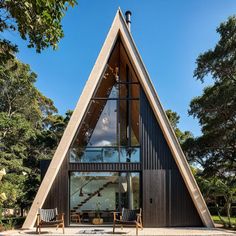 a triangular shaped building with two chairs in front of it