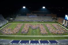 an aerial view of the football field at night with fans in the bleachers