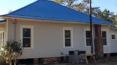 a small white house with a blue roof