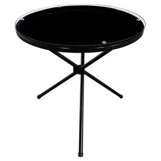 a black table with two legs and a round glass top on it's base