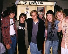 a group of young men standing next to each other in front of a locker with writing on it