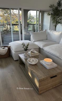 a living room filled with white furniture and lots of windows