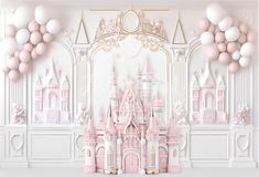 a pink castle is surrounded by balloons in front of a white wall with gold trim