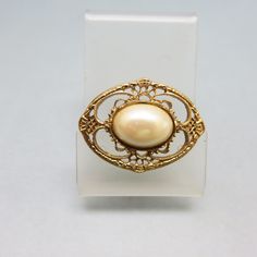 This handsome goldtone metal, and faux pearl brooch dates to the 1960s.  It measures 1 1/8th inches tall and 1 1/2 inches wide and is in excellent vintage condition. It is made in antiqued goldtone metal with an oval faux pearl cabochon in a Victorian styled setting. There is a locking safety clasp and the piece is unsigned but has the signature back pattern of the 1928 Jewelry Company.  We will send this to you in a lovely gift box for easy gift giving. For other fantastic pieces of vintage sil 1928 Jewelry, Pearl Pin, Silver Box, Pearl Brooch, Jewelry Companies, Easy Gifts, Amethyst Crystal, Vintage Silver, Lovely Gift