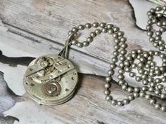 This is a vintage watch movement, just the gears. It doesn't work its just for the beauty of the inside of old watches. A conversation piece. Authentic antique/vintage pocket watch movement. Great piece for your steampunk look. I T E M ∙ S P E C I F I C A T I O N S - NECKLACE: 28" stainless steel bead ball chain - PENDANT: Watch gears are 1 1/8" round, backing is glued and makes the pendant 1 1/2" long C A R E ∙ T I P S We don’t want your special moment to fade. To maintain the quality of your j Steampunk Silver Pocket Watch With Locket, Silver Steampunk Pocket Watch With Locket, Antique Silver Nickel-free Pocket Watch, Antique Nickel-free Silver Pocket Watch, Silver Metal Round Pendant Pocket Watch, Silver Round Pendant Pocket Watch, Steampunk Silver Pendant Necklace, Steampunk Silver Necklace With Round Pendant, Silver Steampunk Pendant Necklace