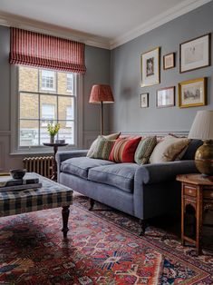 a living room filled with furniture and pictures on the wall