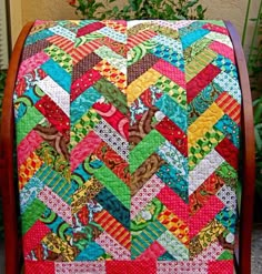 a multicolored quilt on a wooden chair