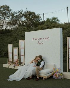 a bride and groom sitting on a couch in front of a sign that says it was you so sweet