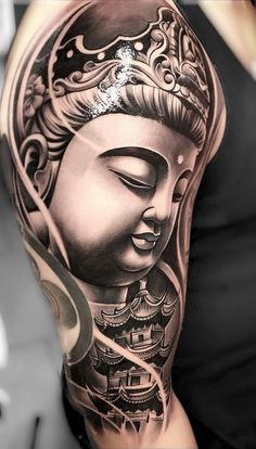 a woman's half sleeve with a buddha tattoo on her arm and head in the middle