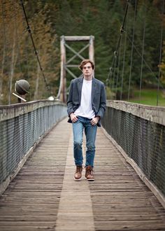 a man standing on a bridge with his hands in his pockets