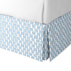 the blue and white bedspread has an interesting pattern on it's headboard