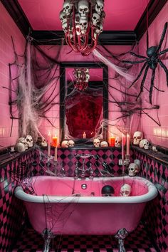 a bathroom decorated for halloween with pink bathtub, skulls and spider webs on the walls