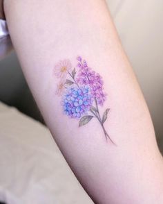 a woman's arm with a flower tattoo on the left side of her arm