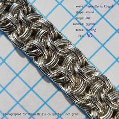 a close up of a chain on a piece of paper with blue lines in the background