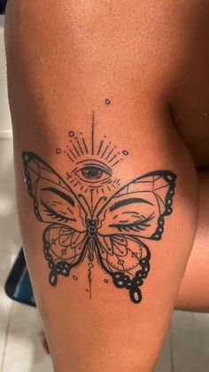 a woman's thigh with a butterfly tattoo on the leg and an all seeing eye