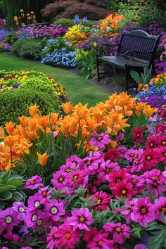 a garden filled with lots of colorful flowers next to a park bench on top of a lush green field