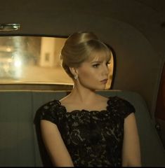 a woman sitting in the back seat of a car with her hand on her hip