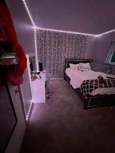 a bed room with a neatly made bed and lights on the wall next to it