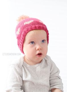 a baby wearing a pink knitted hat