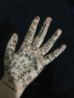 a person's hand with writing on it and tattoos all over the palm area