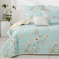 a bed covered in blue and white floral bedspread