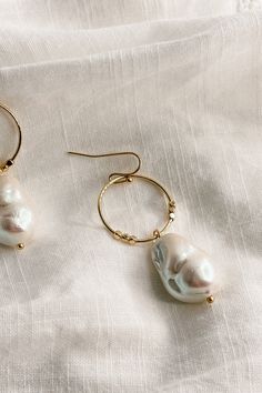 The Shelby Pearl and Gold Mini Hoop Dangle Earrings, where classic elegance meets modern sophistication. These earrings are a testament to timeless beauty, designed to add a touch of luxury to any ensemble. Crafted with meticulous attention to detail, each earring features a small gold hoop that delicately frames the earlobe, exuding understated glamour. Suspended from the hoop is a mesmerizing pearl medallion dangle, radiating elegance with every movement. The convenient hook back closure ensur Classic Metal Jewelry With Pearl Drop, Classic Hoop Single Earring, Elegant Metal Hoop Earrings For Everyday, Everyday Elegant Metal Hoop Earrings, Elegant Everyday Metal Hoop Earrings, Classic Single Hoop Earring, Timeless Metal Hoop Jewelry, Everyday Metal Hoop Earrings With Pearl Drop, Timeless Dangle Hoop Earrings