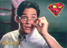 a man wearing glasses and a superman shirt