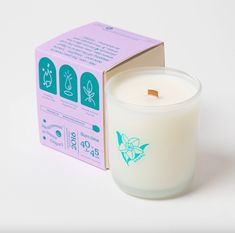 a white candle sitting in front of a box