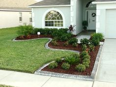 a house with landscaping in front of it and a driveway leading to the front door