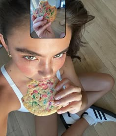 a woman eating a cookie with sprinkles on it