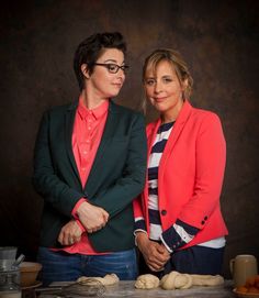 two women standing next to each other in front of bread