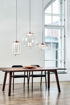 a dining table with three lights hanging from it