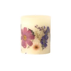 a white candle with purple and pink flowers on it