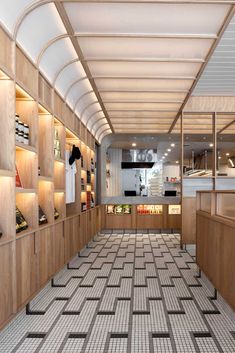 the inside of a restaurant with tiled flooring and wooden shelves filled with food items