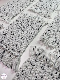 crocheted squares with fringes are arranged on a white tablecloth that is laid out