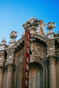 an old building with a large sign on it's side and ornate architecture in the background