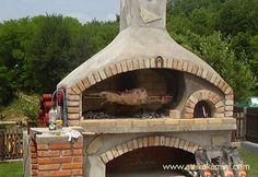 an outdoor brick oven with chicken cooking in it