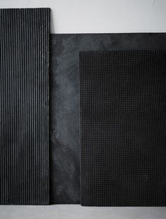 two pieces of black paper sitting next to each other