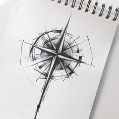 a spiral notebook with a pen and ink drawing of a compass on the front cover