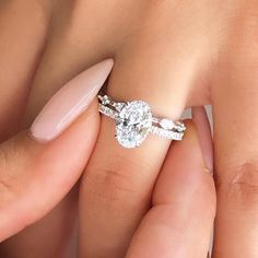 a woman's hand holding a diamond ring with two diamonds on the middle finger