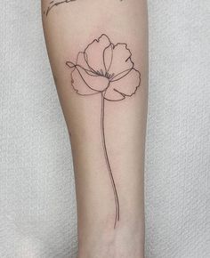 a single flower tattoo on the left arm and leg, with words written in cursive writing